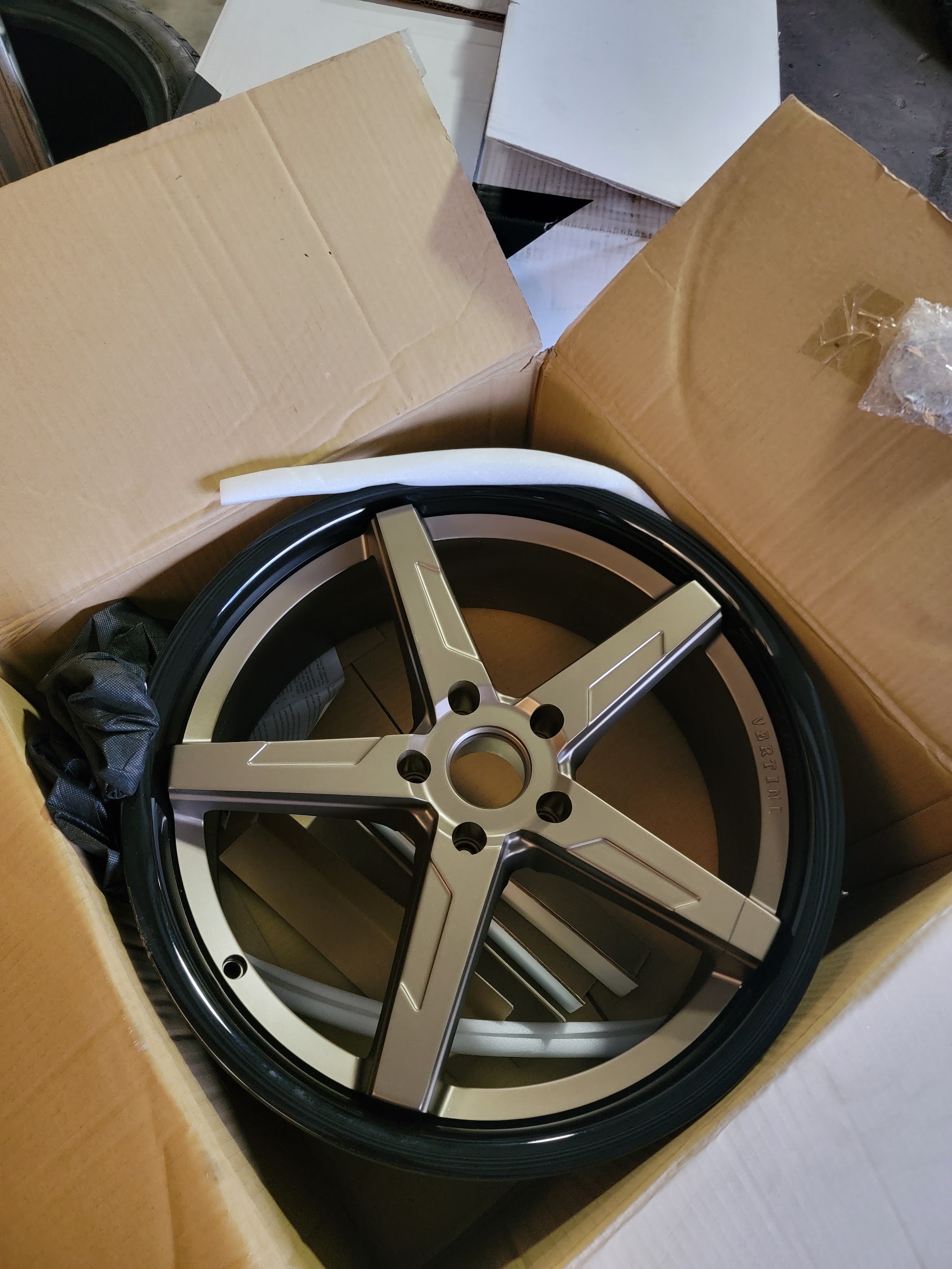 A new five-spoke alloy wheel still in its box