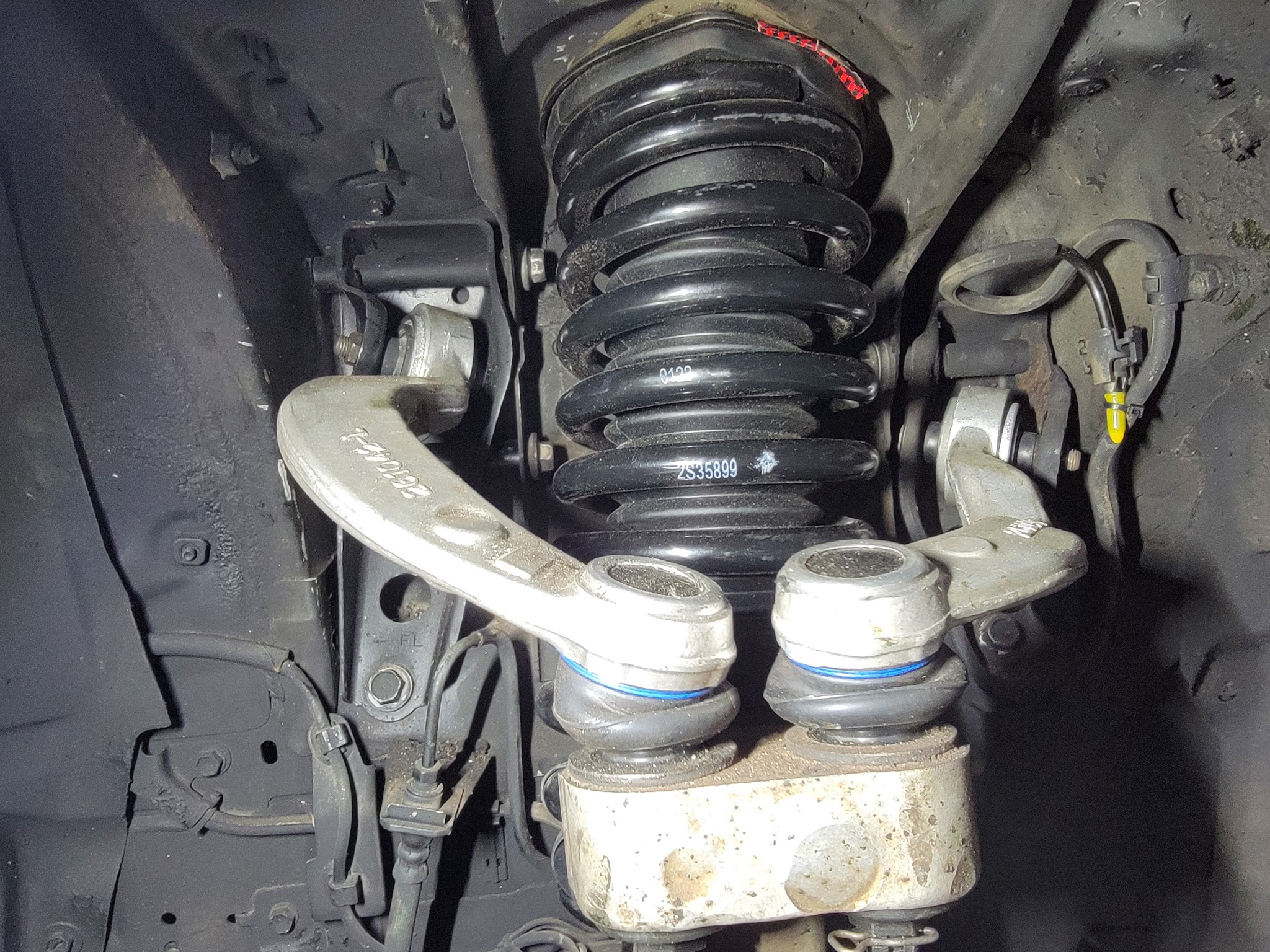 Front suspension control arm and coil spring